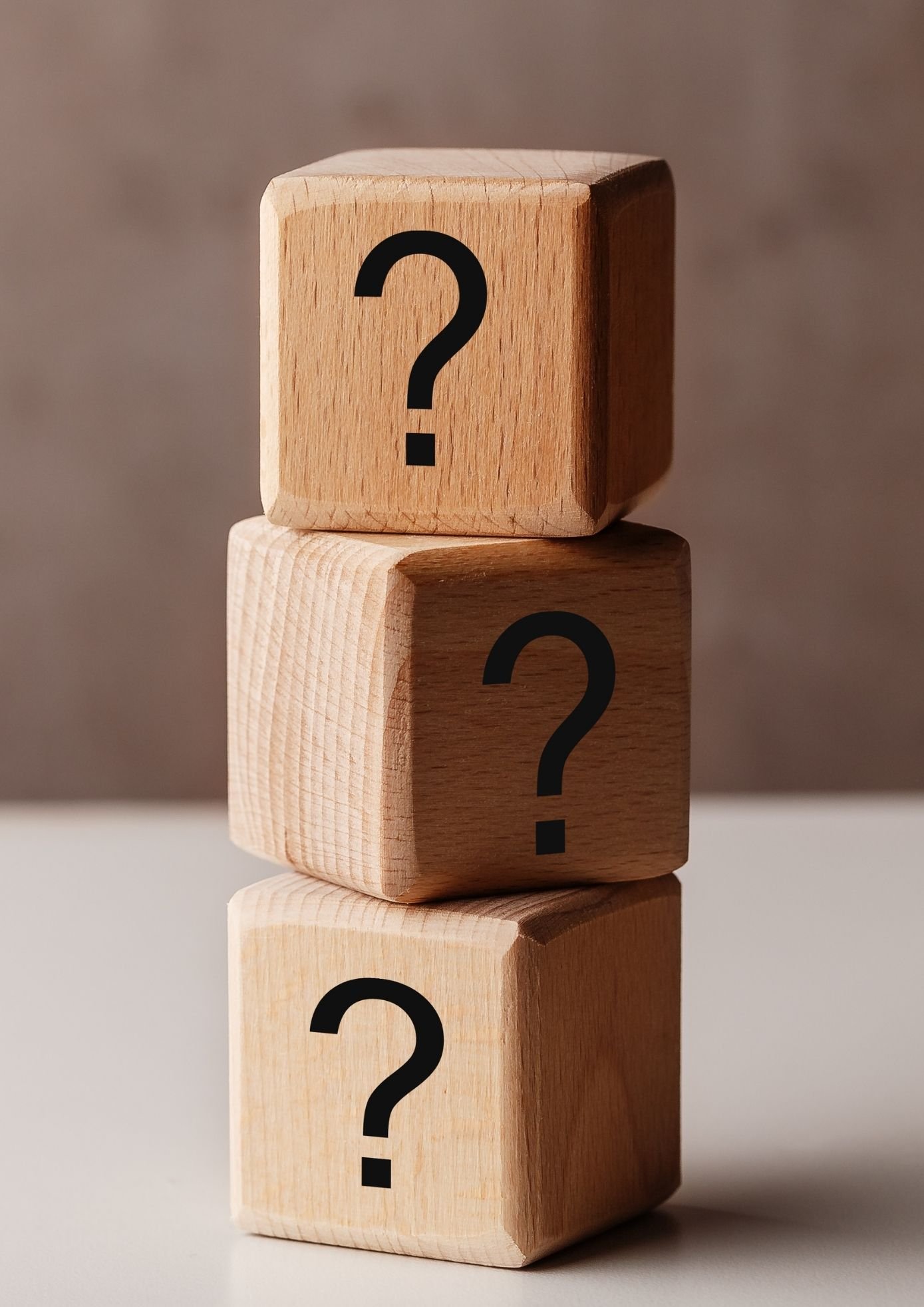Wooden blocks with question marks representing uncertainty